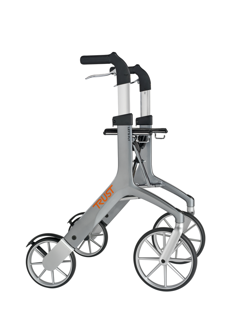 Load image into Gallery viewer, Bild tagen i sidvy. Grå Let’s Fly rollator från Trust Care, ergonomiska handtag och stora framhjul.